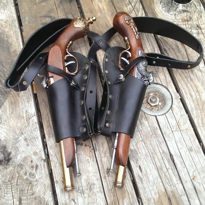 Black leather dual flintlock shoulder holster shown in flat lay on wooden surface