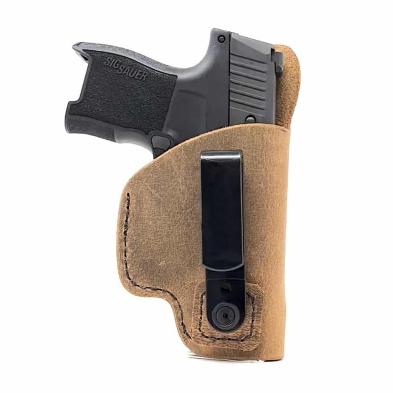 Brown leather tuckable IWB holster with black clip holding a compact pistol