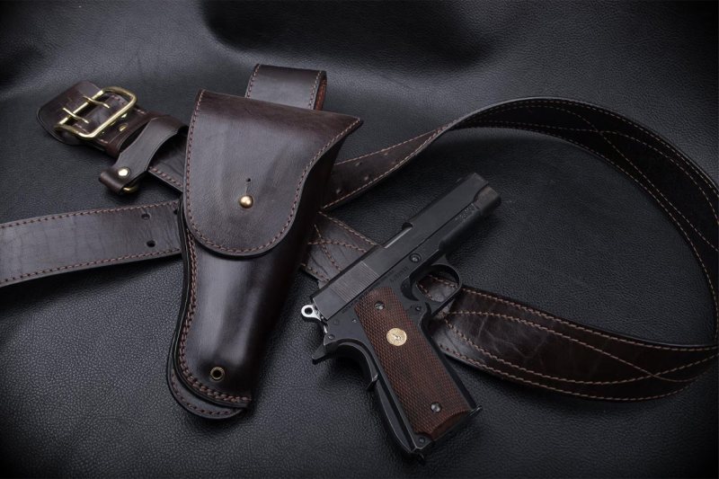 complete set displayed with matching belt and handgun on black leather surface