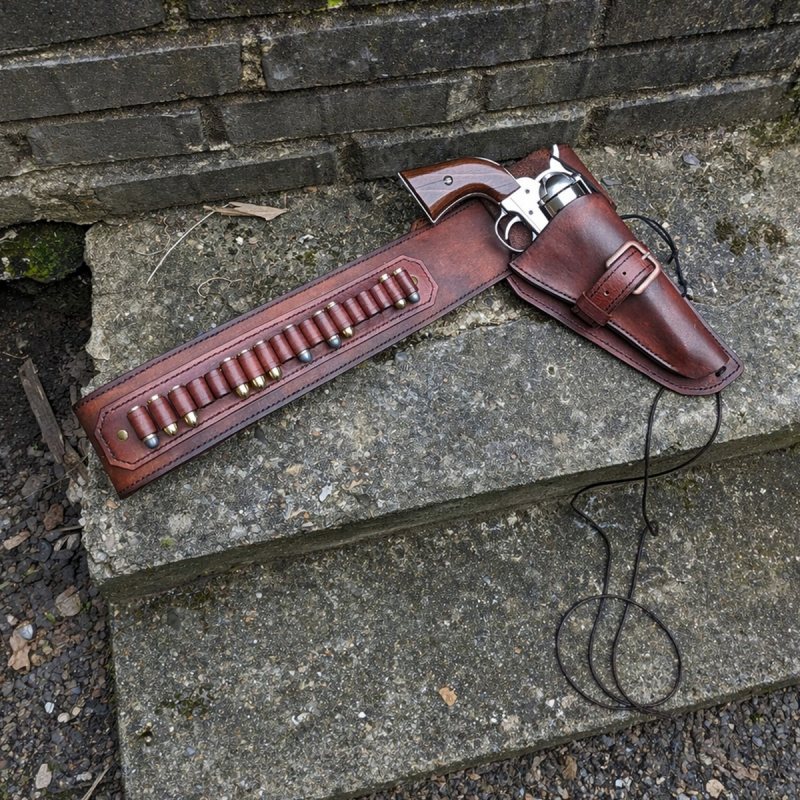 Western Leather Buscadero Gunbelt with Revolver Holster and Cartridge Loops shown on outdoor stone steps