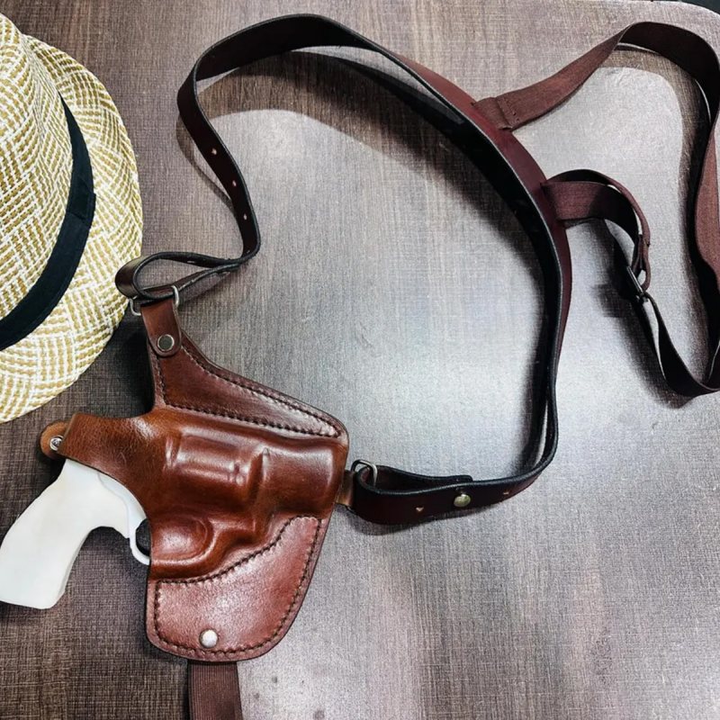 Mahogany leather horizontal shoulder holster with harness displayed on tabletop