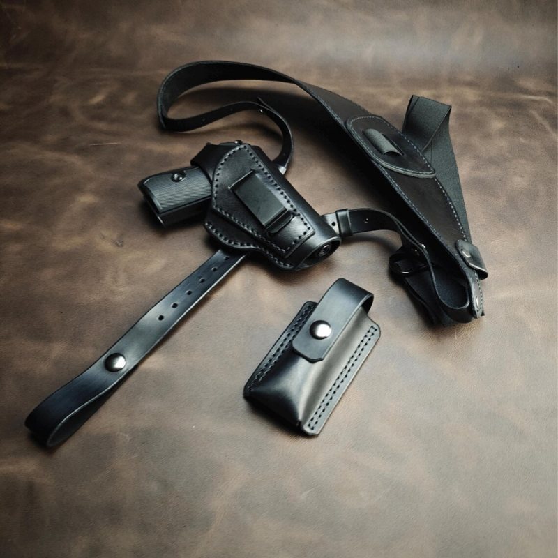 Black leather Walther PPK/S shoulder holster set laid flat with pistol holster, magazine pouch, and adjustable strap system