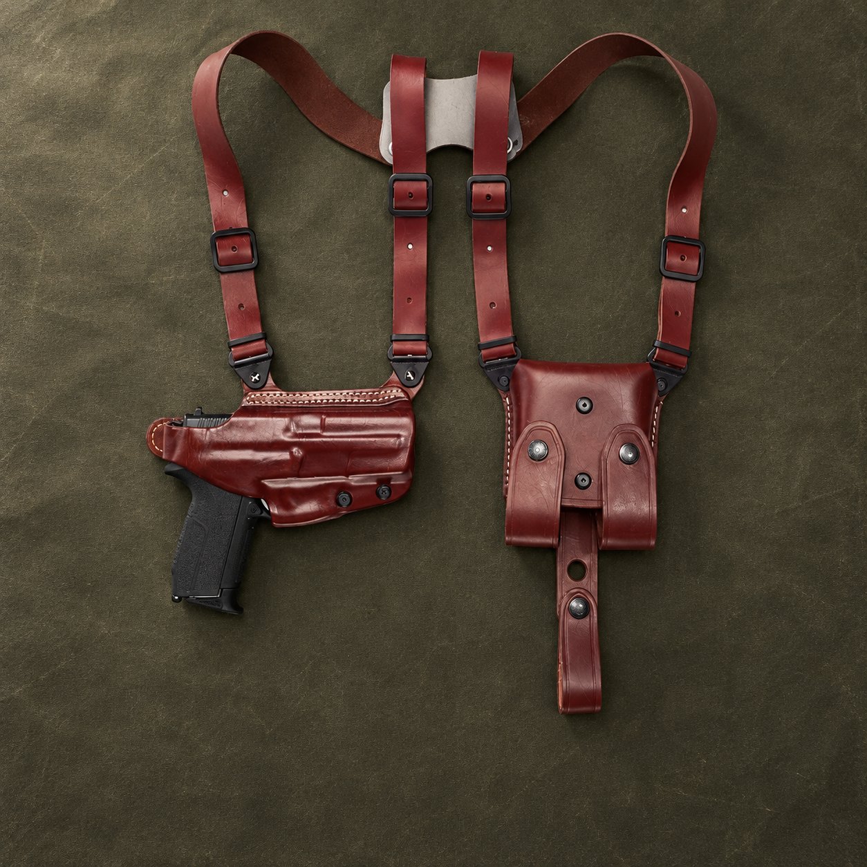Braunes horizontales Leder-Schulterholster mit doppelter Magazintasche auf einer olivfarbenen Arbeitsfläche